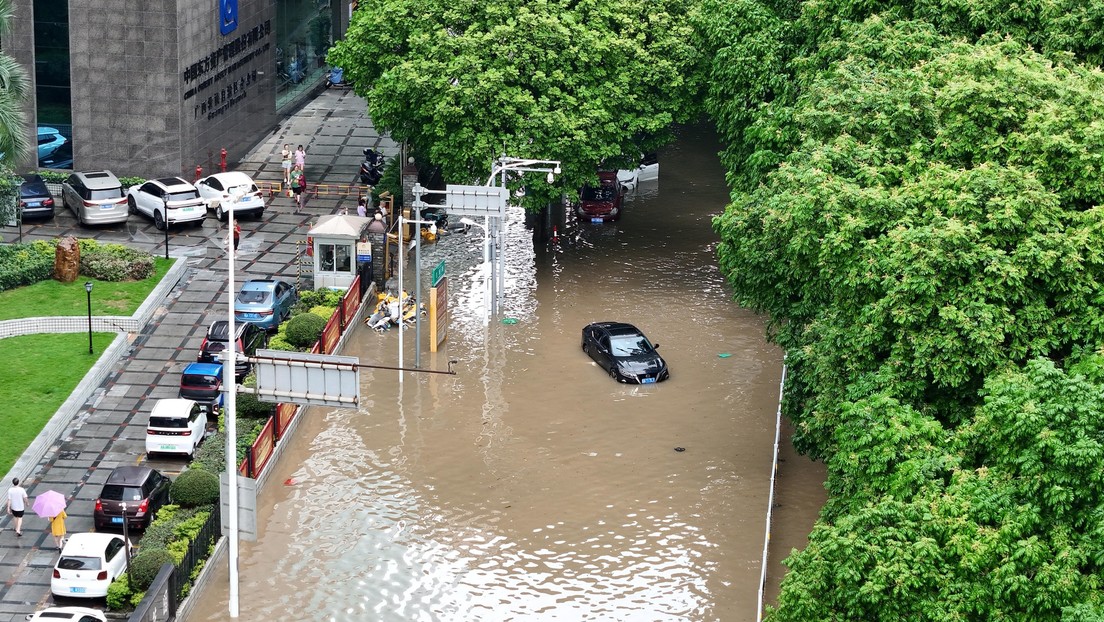 Habitantes de ciudades chinas caminan con el agua hasta el pecho durante fuertes lluvias